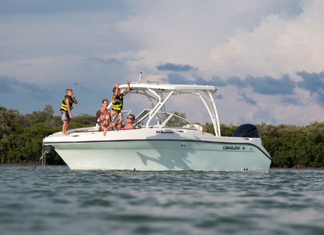 family of four on a dual console boat with children jumping off the bow